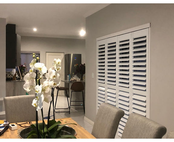 Open-plan kitchen and dining area with white shutters and an orchid, Kyalami