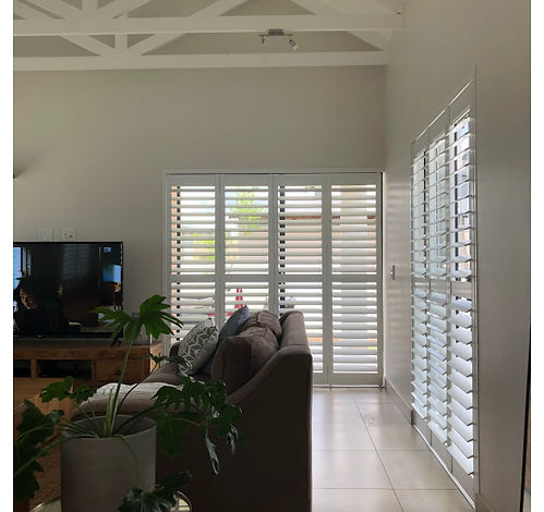 Sliding shutters across patio doors in a bright living room, Midstream